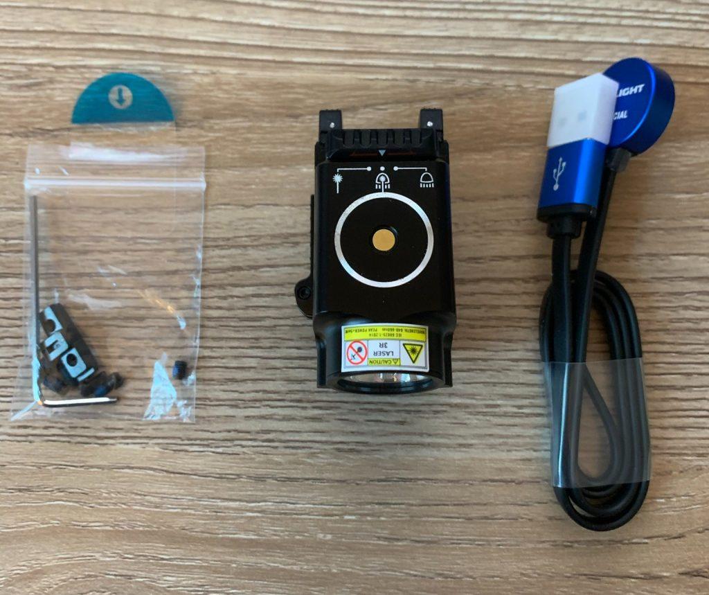 The light, charging cable, screws & allen wrench. The ambi paddles are activated with downward pressure. Also visible is the light setting selector, which allows for combo, light-only, and beam-only operation. The circular port is where the magnetic charging cable attaches.