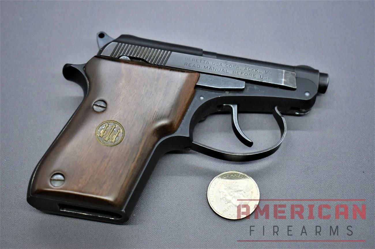 A side-by-side image of the Beretta Bobcat pistol and a US quarter, showing the pistol's small size in comparison to the coin.